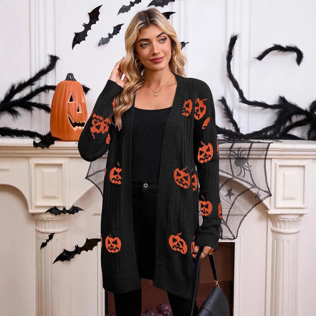 Women's black knitted cardigan with an orange jacquard pumpkin head pattern on the front.