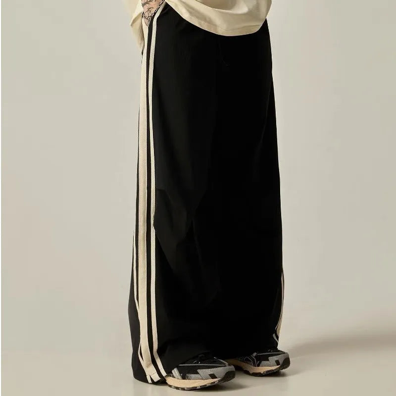 Black wide-leg men's climbing trousers with a high waist on a neutral background.