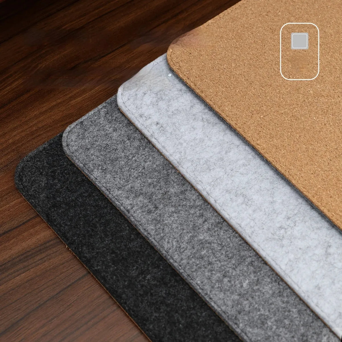 Oversized black and gray felt desk mat with cork base on a wooden desk