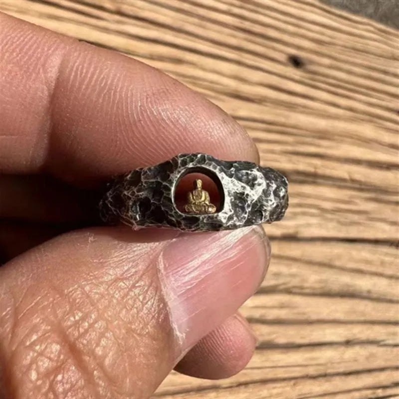 Close-up of a hand-forged copper ring with a Grotto Buddha design and rock texture.