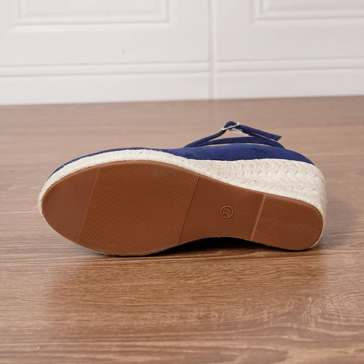 Dark blue suede straw woven wedge closed toe high heels with buckle fastening on a white background