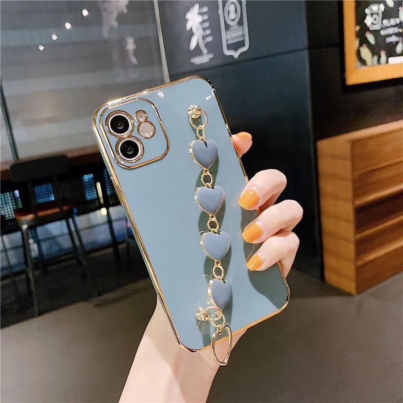 Solid colour silicone phone case with an integrated white protective bracelet on a table.