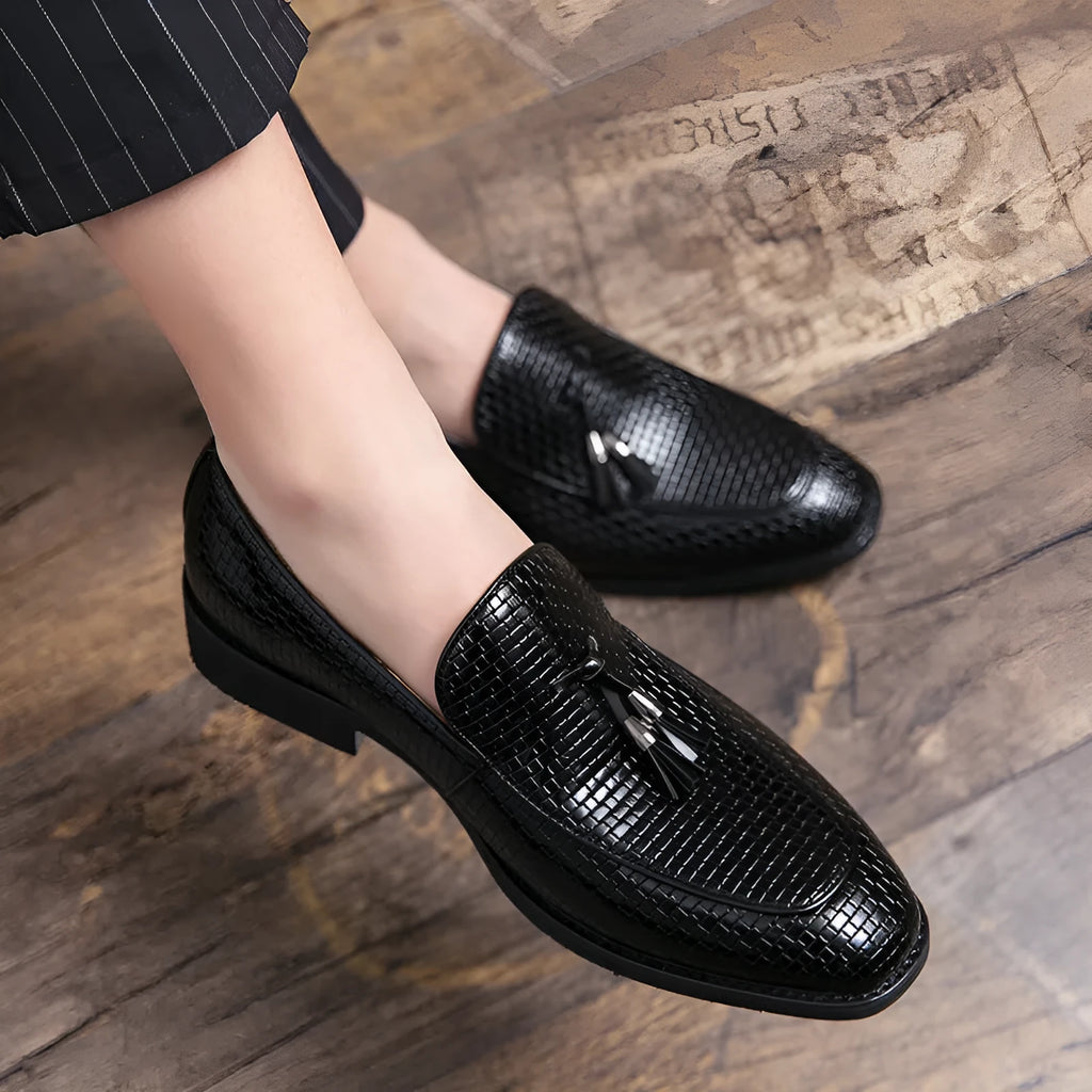 Men's black pointed toe slip-on shoes with a tassel detail on the artificial PU upper.