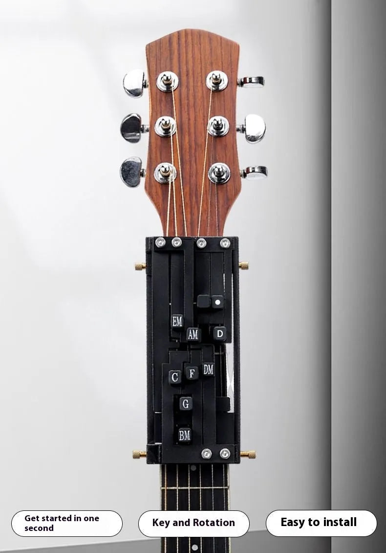 A black automatic chord maker device for guitar practice, shown next to an acoustic guitar.