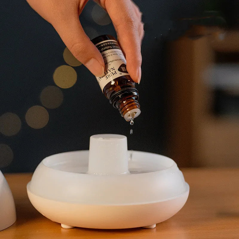 Black flame effect humidifier diffuser with LED lights on a wooden surface