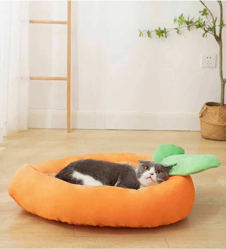 Orange carrot-shaped dog nesting bed with a raised bolster edge and a separate soft blanket, shown in two sizes.