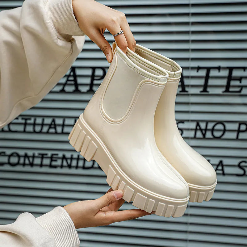 Creamy-white low tube PVC rain boots with a flat heel and non-slip sole on a plain background.