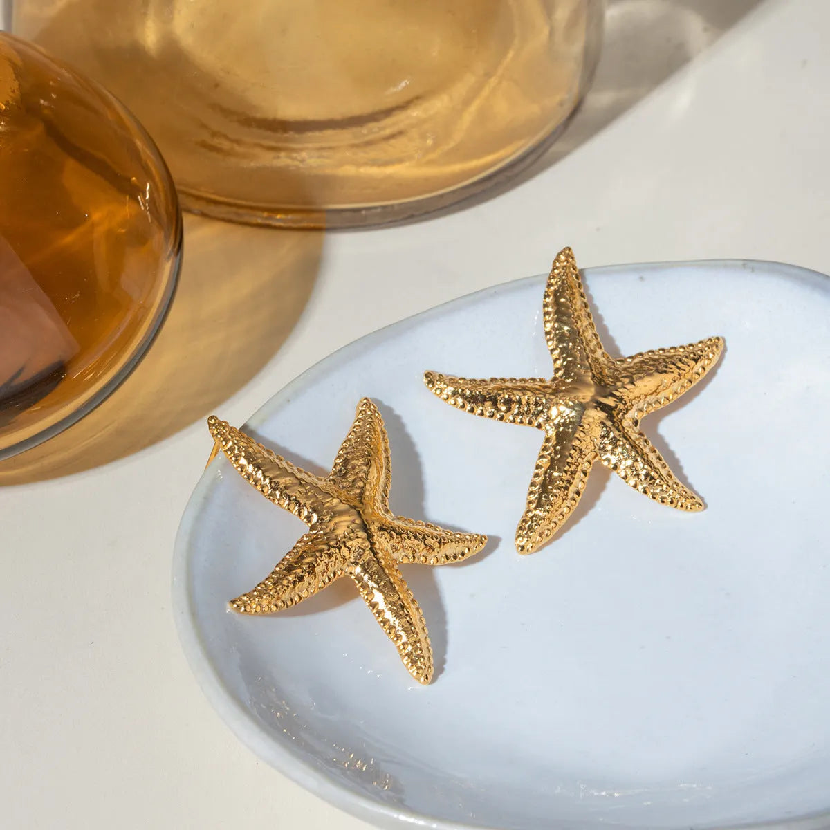 Gold starfish earrings with electroplated finish on stainless steel, animal zodiac design