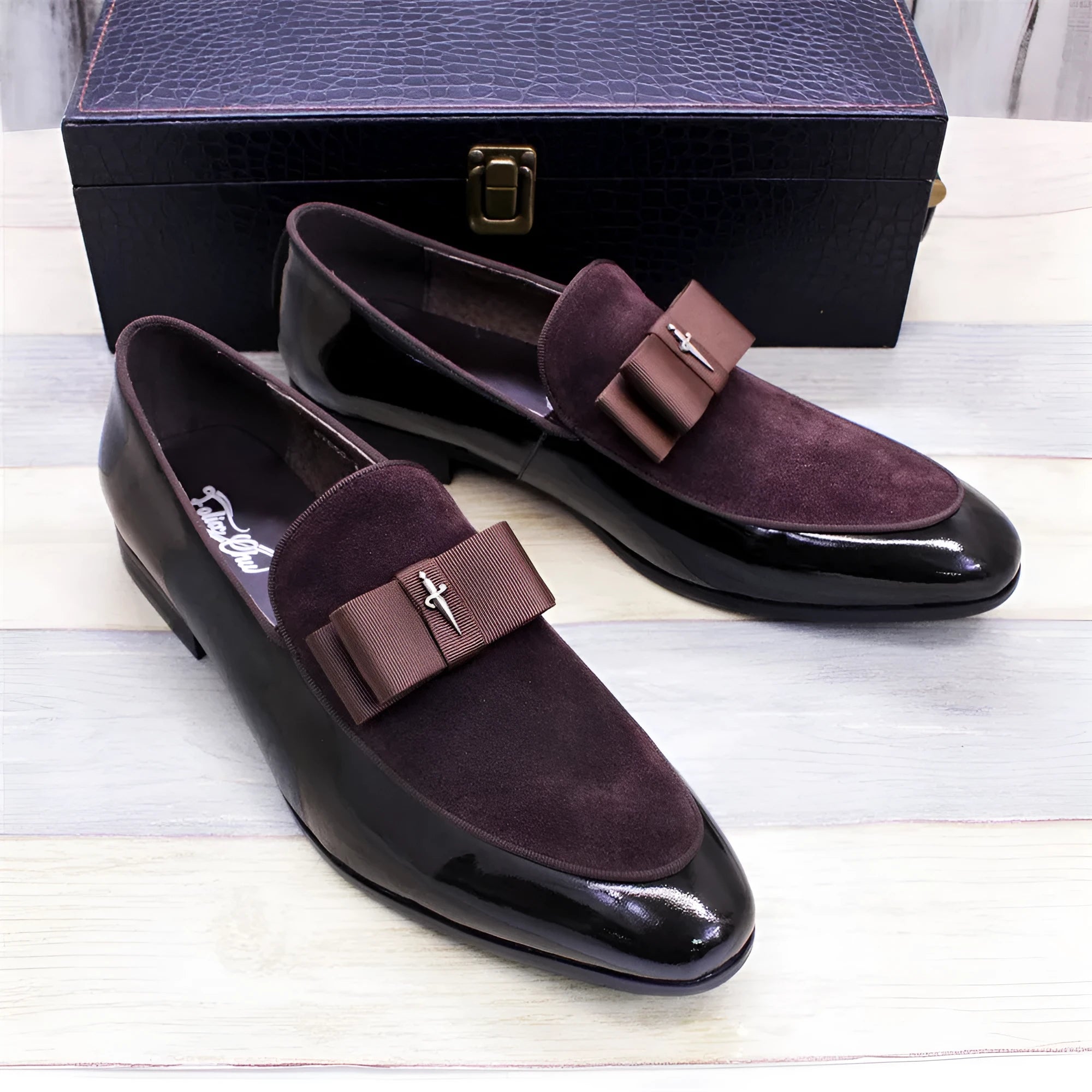 Men's glossy black patent leather low-top shoes with a tassel detail on a white background