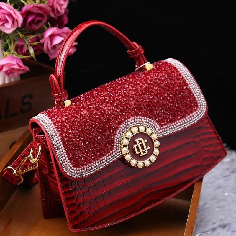 Patent leather diamond portable shoulder bag in black, brown, pink, and red with lock detail and single strap