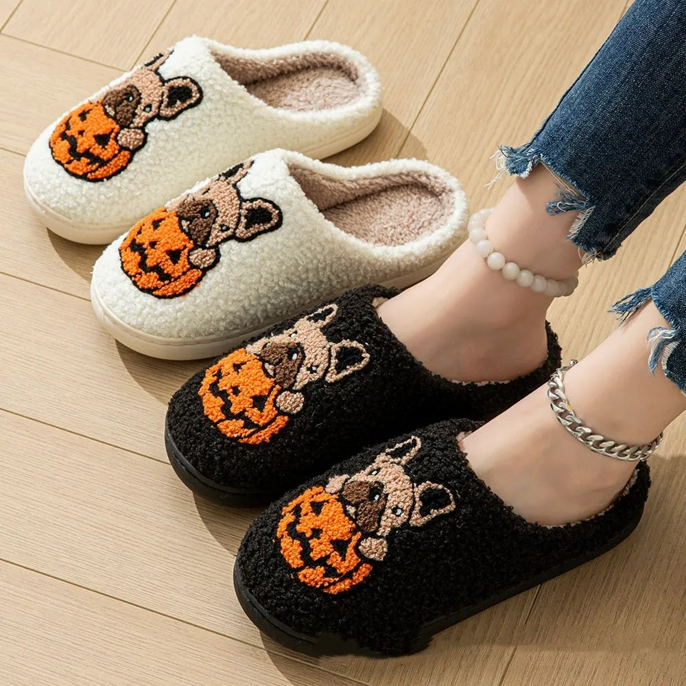 Black plush Halloween slippers with pumpkin print and a thick, textured TPR rubber sole.