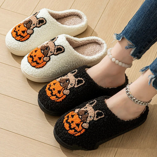 Black plush Halloween slippers with pumpkin print and a thick, textured TPR rubber sole.