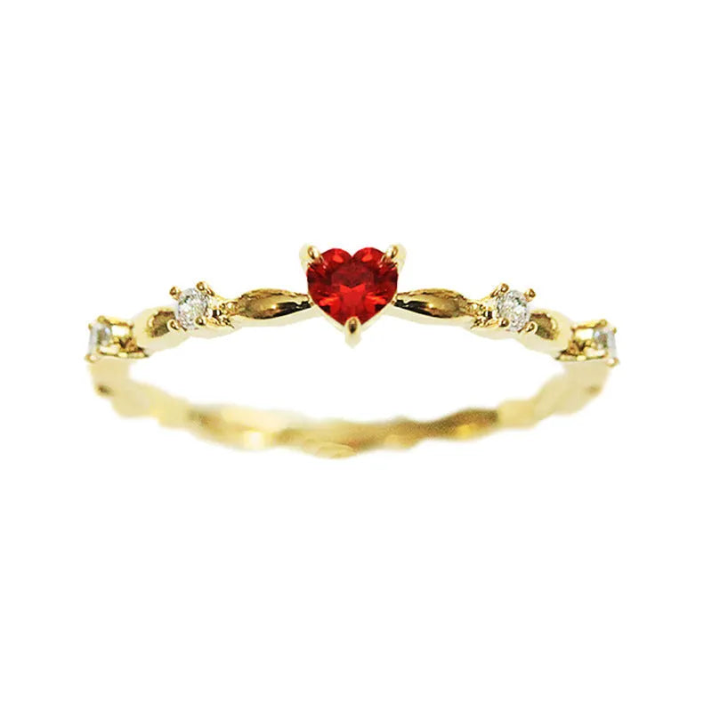 Copper fashion ring with peach heart zircon detail in gold or silver electroplating, shown on a finger.