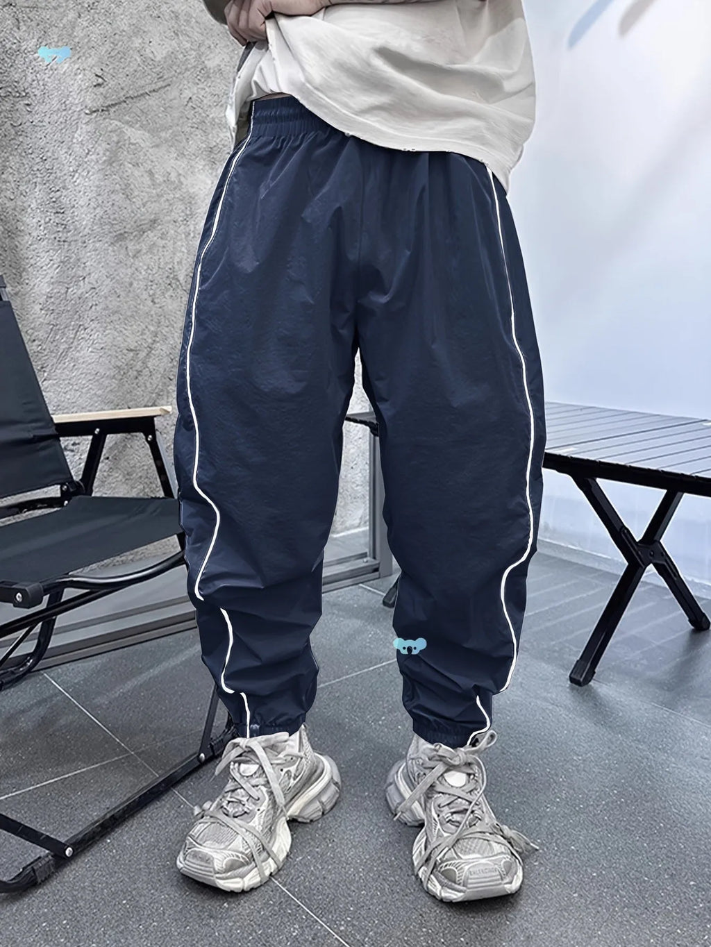 Man wearing loose grey cropped bamboo fibre sports pants in a casual setting.