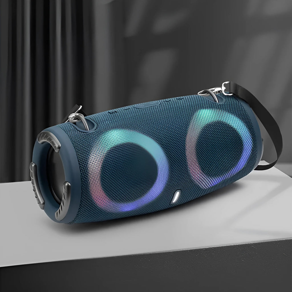 War Drum portable Bluetooth speaker with glowing RGB light ring in camouflage colour, sitting on grass.