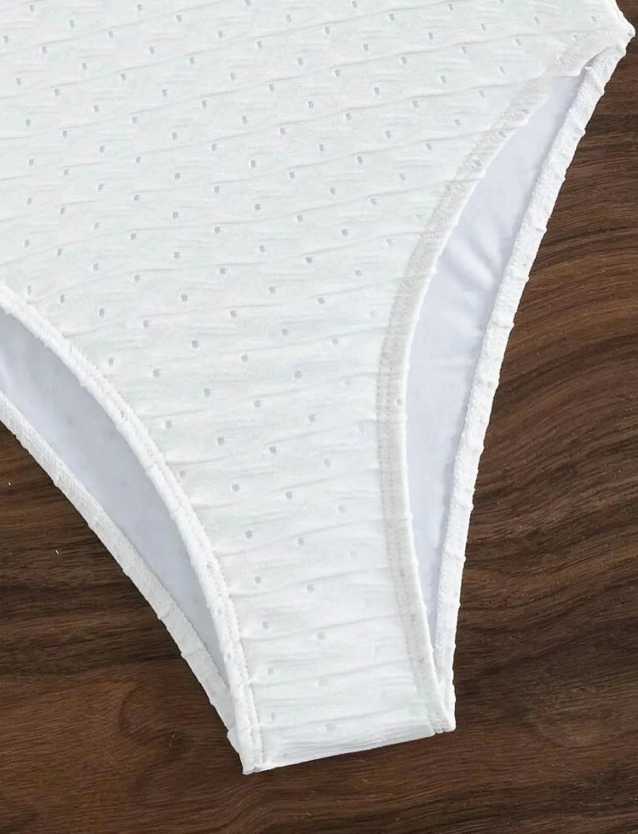White sling-style one-piece swimsuit for women on a mannequin