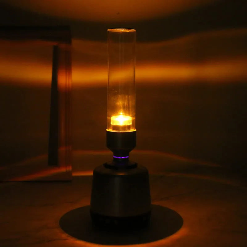 White silver cylindrical Bluetooth speaker with candlelight glow, showing push buttons, dimensions 90mm by 277mm.