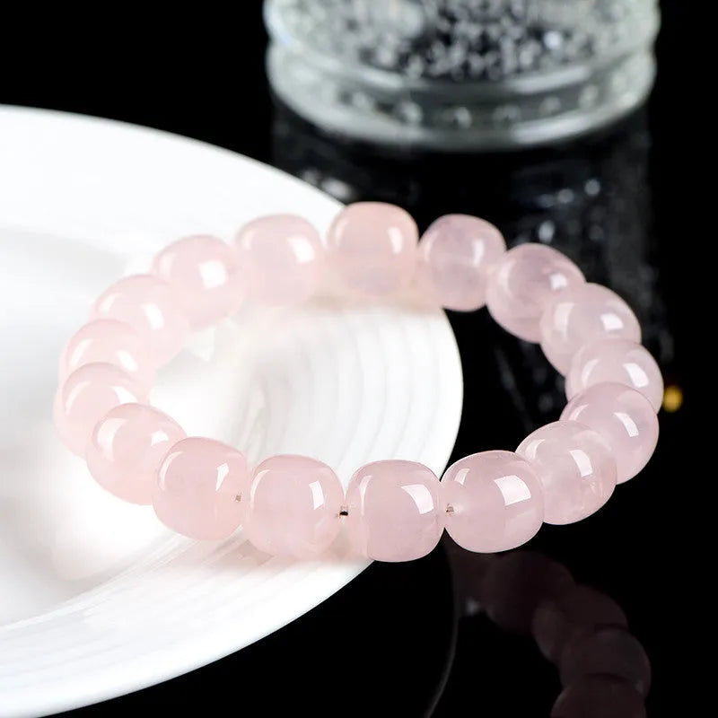 Pink crystal barrel bead bracelet with geometric beads on an elastic cord