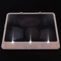Black or white magnifying glass with integrated LED reading lamp, showing 180x140mm size and 3x magnification lens.