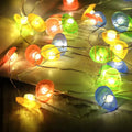 Easter carrot and rabbit shaped battery-operated LED decorative string lights on a dark background.