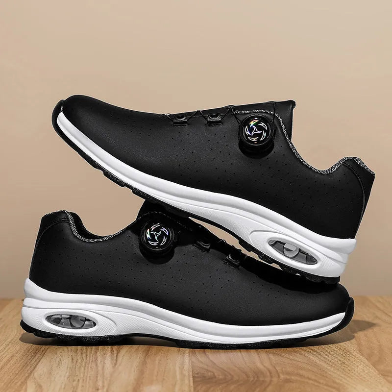 Black and white low-top tennis shoes with mesh upper and cross-shoulder straps on a composite sole.