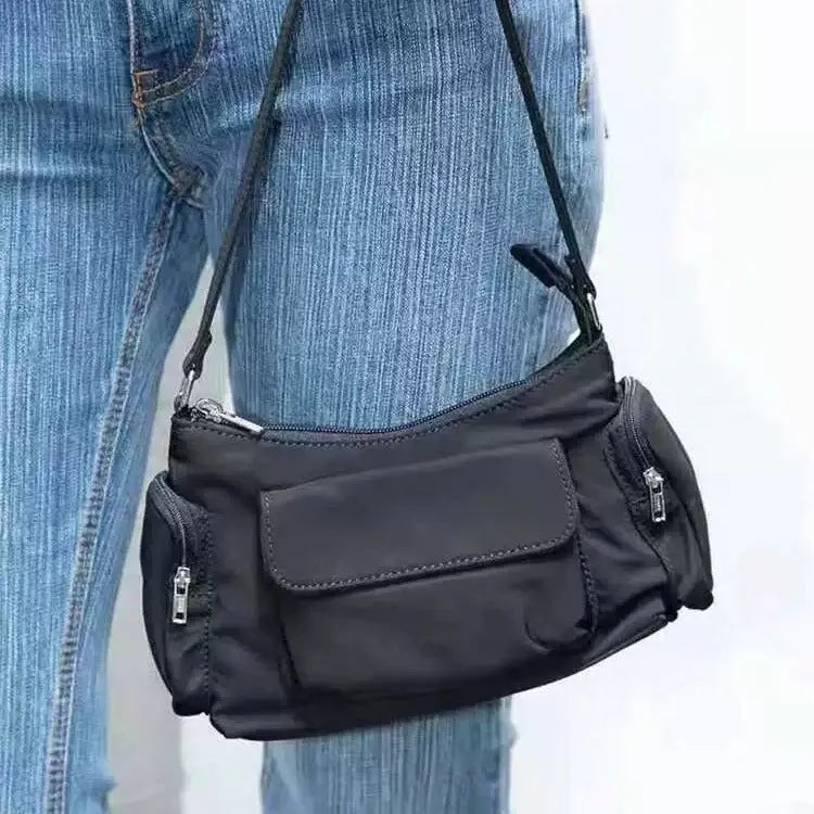 Simple black lightweight nylon shoulder bag with double pockets showing side line detailing
