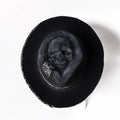 Handmade conical skull hat in wool felt and denim, shown from the side, highlighting its structured crown shape.