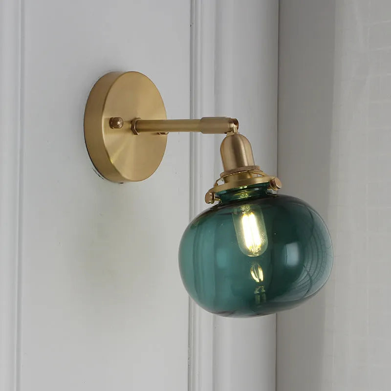 Pumpkin-shaped glass wall lamp in blue and transparent water ripple finishes mounted on a wall.