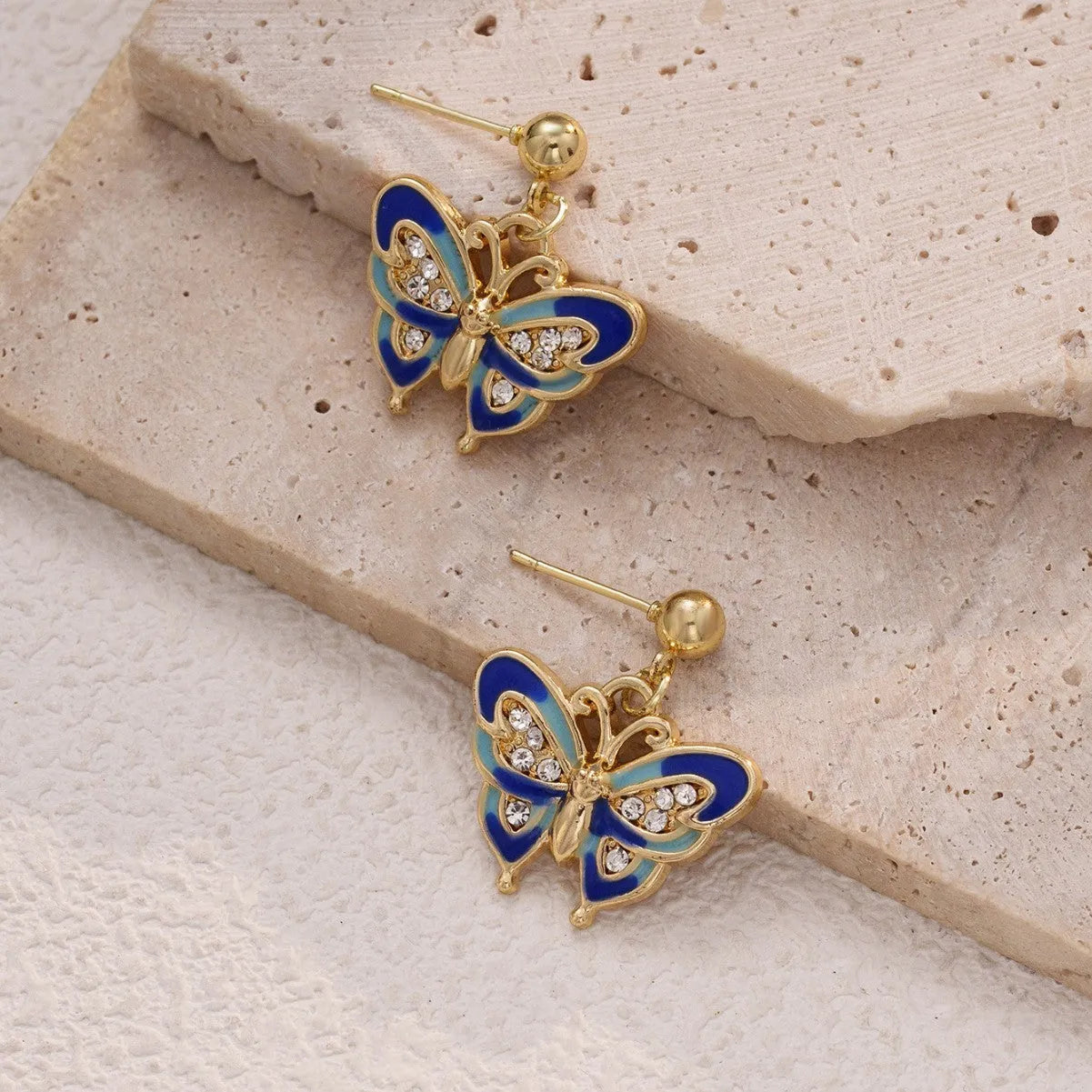 Dripping oil butterfly stud earrings in zinc alloy, classic style, colour O-4-17, on display
