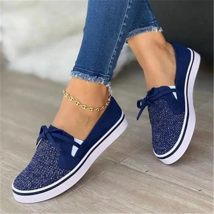 Women's low top flat shoes with cloth upper and shallow mouth cut, shown in white, red, blue, and black