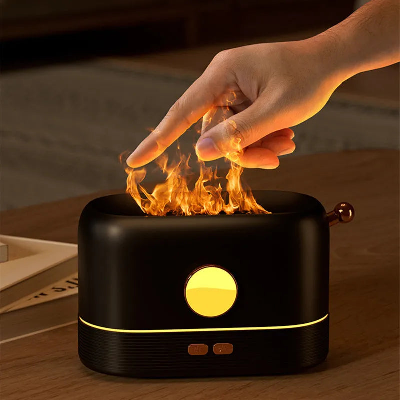 Black USB humidifier with simulation flame light effect and water mist output on a wooden desk.