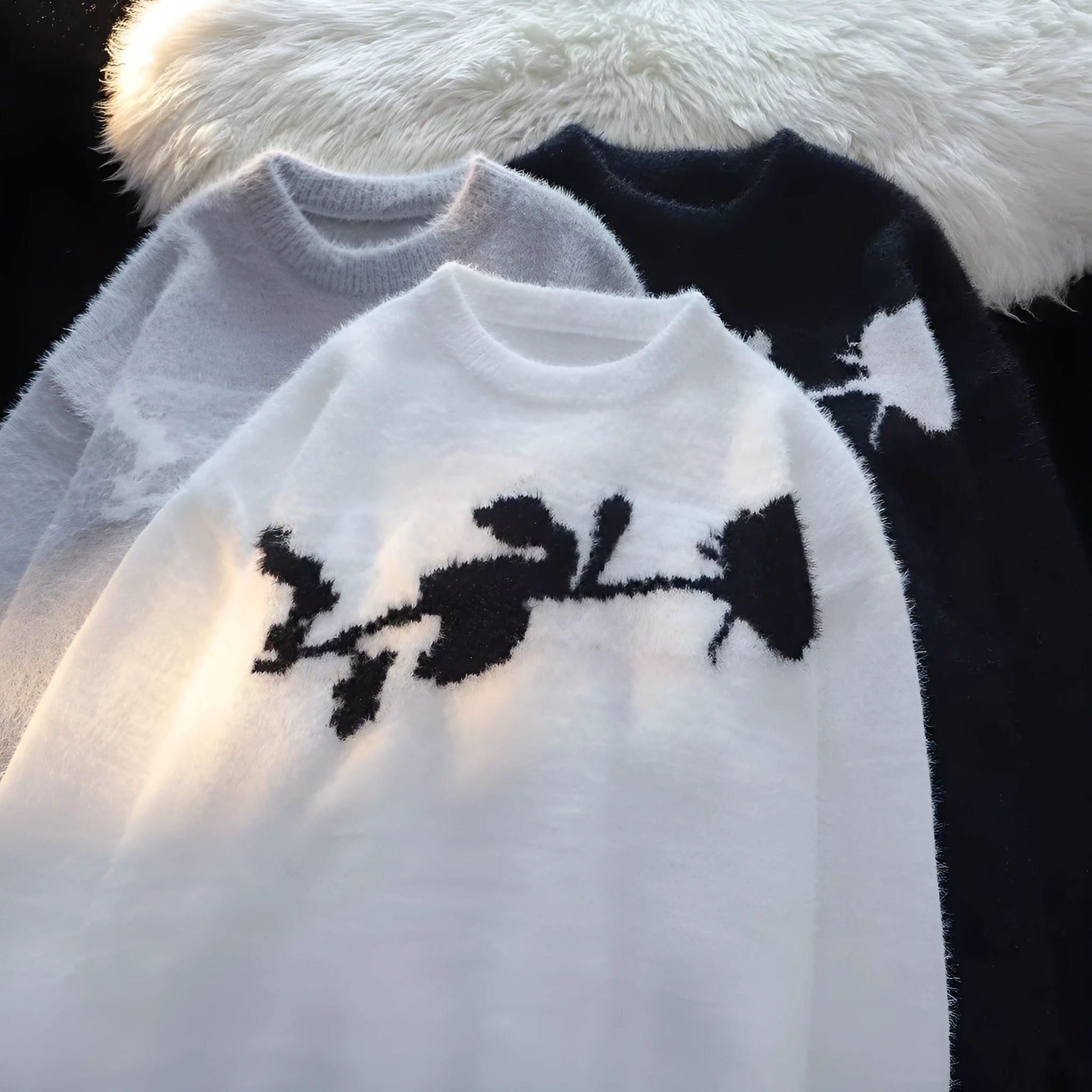 Man wearing a dark grey pullover sweater with a large rose-coloured flocking horse print on the chest.