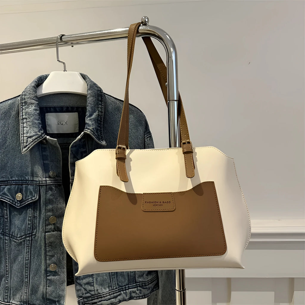 Women's square PU tote bag in black with double straps, showing external sandwich pocket and sewing line detail.