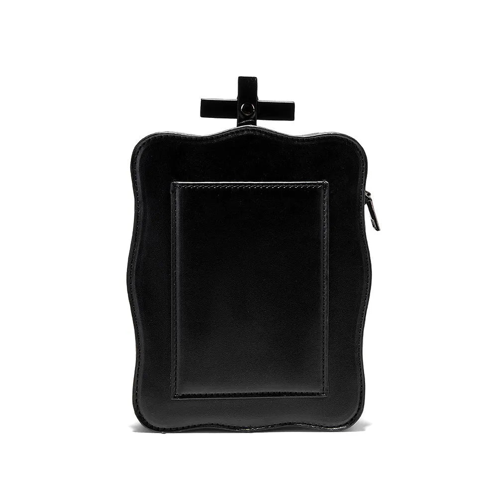 Black vertical square mini crossbody bag with embossed skull design, metal chain strap, and zipper closure