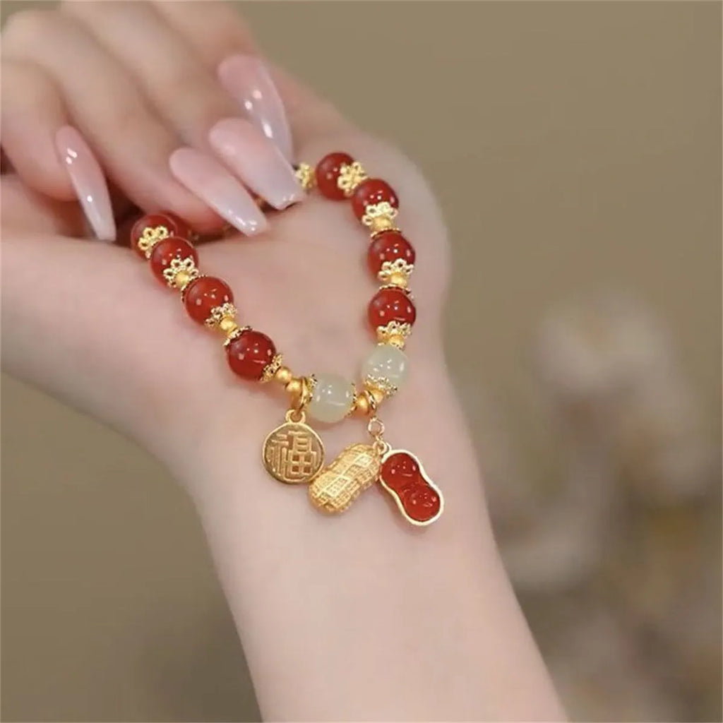 A glass and coloured glaze bracelet with a rabbit motif and a peace buckle clasp.