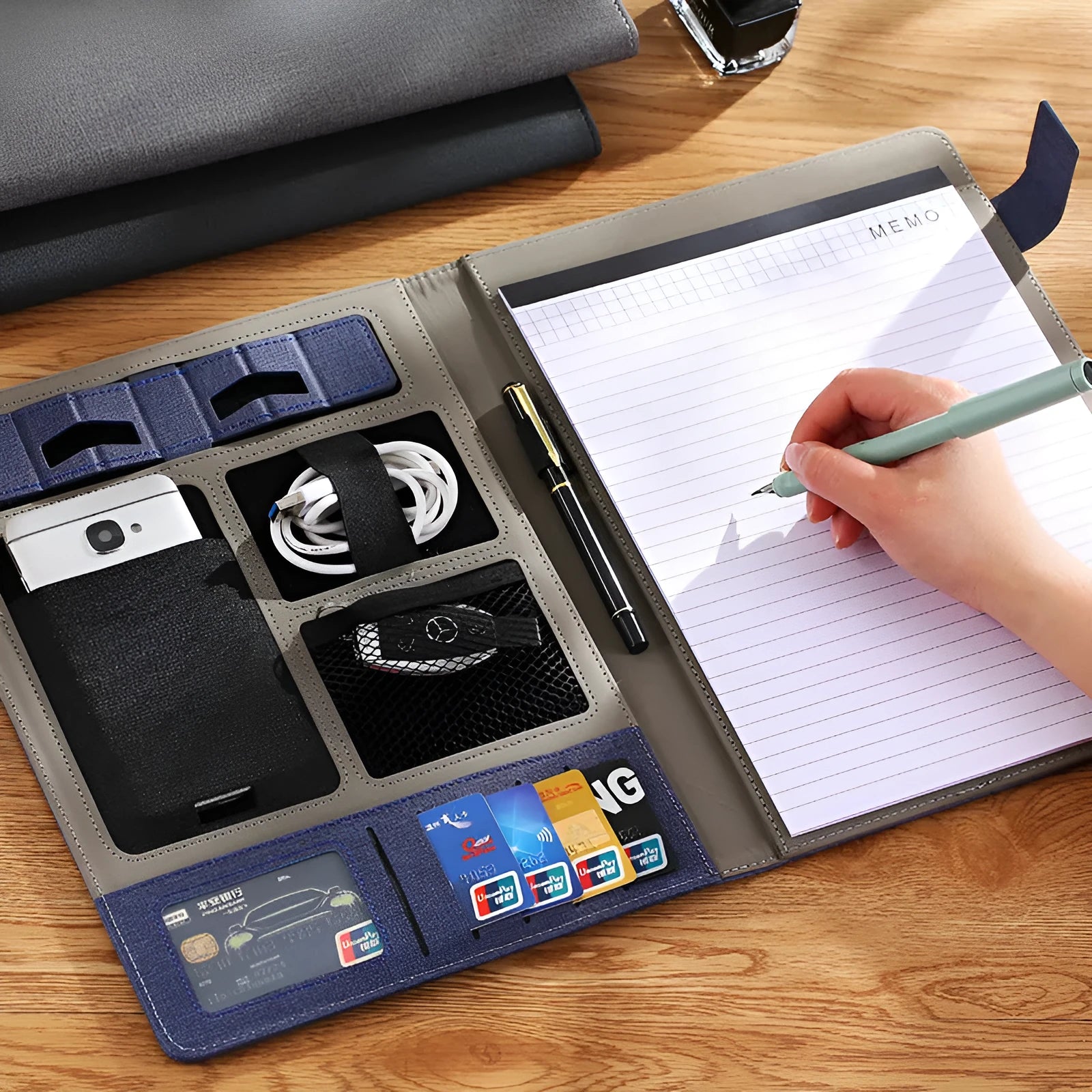 Black leather A4 business folder with 35mm thick sides, shown open on a desk.