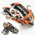Reinforced non-slip crampons for shoes in black colour with large teeth, shown on a snowy surface