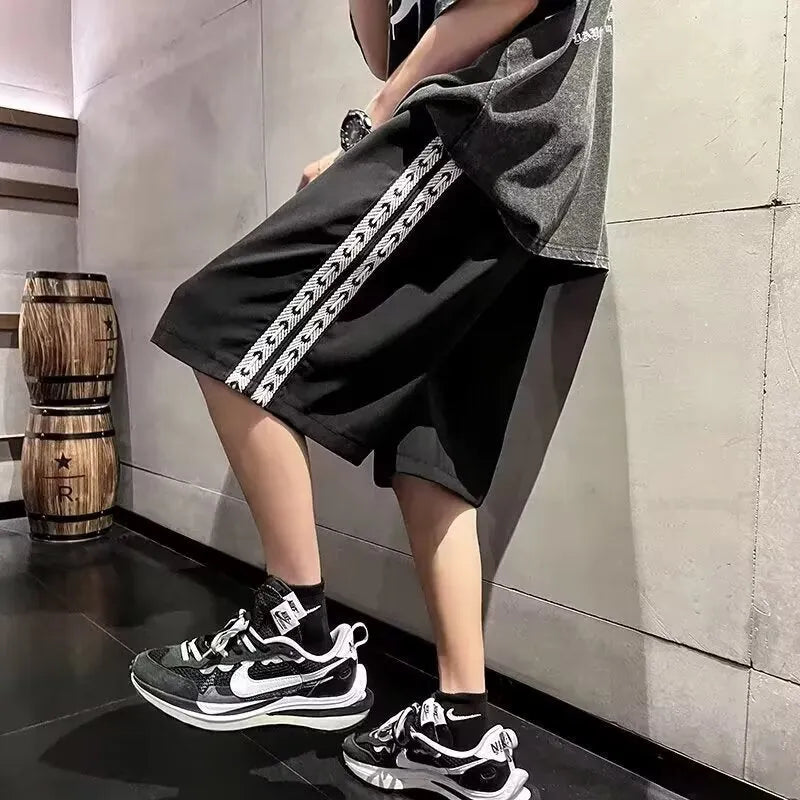 Man wearing black loose-fit baggy track pants, showcasing the casual sports style and roomy cut.
