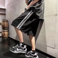 Man wearing black loose-fit baggy track pants, showcasing the casual sports style and roomy cut.