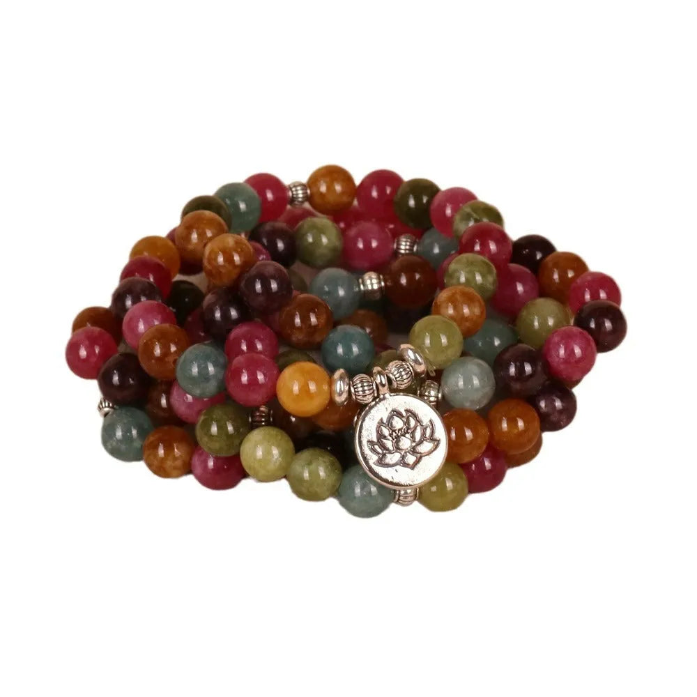 108 bead multi-strand bracelet with natural tourmaline stones and alloy clasp on a wrist.
