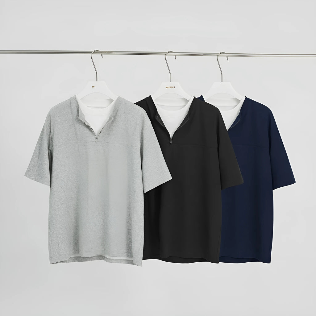 Loose blue zip-through patchwork top on a hanger, showing the false two-piece design and collar detail.