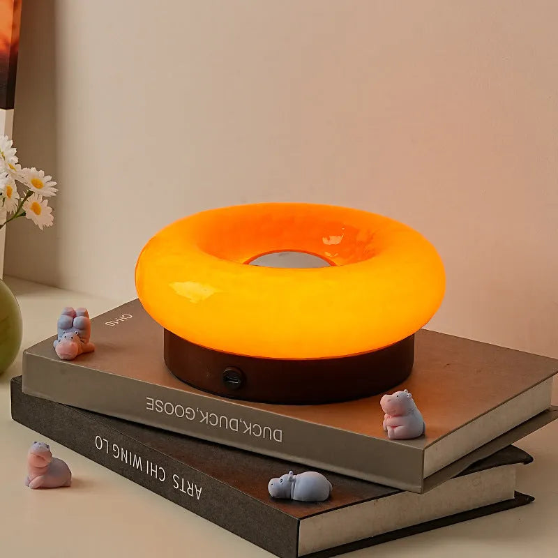 Donut touch table lamp rechargeable with three colour settings, shown in custard, green, orange, or pink.