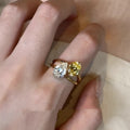 Geometric open copper ring with two sparkling zircon stones in a water drop setting on a model's finger.