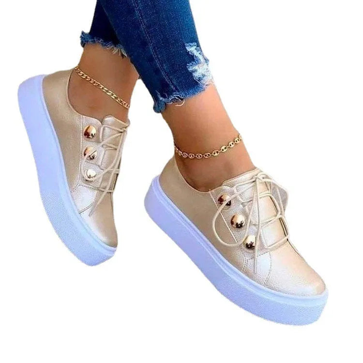 Women's white lace-up flats sneakers with round toe and silver rivet details on the upper.