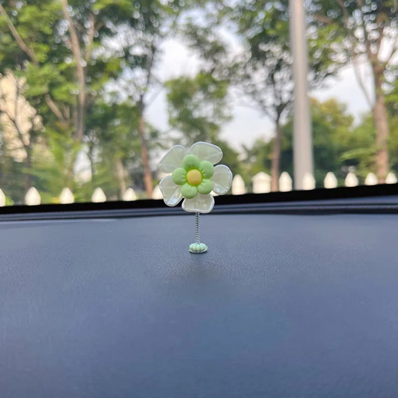 Small colourful plastic swing ornament for car dashboard, shown in multiple colour options.