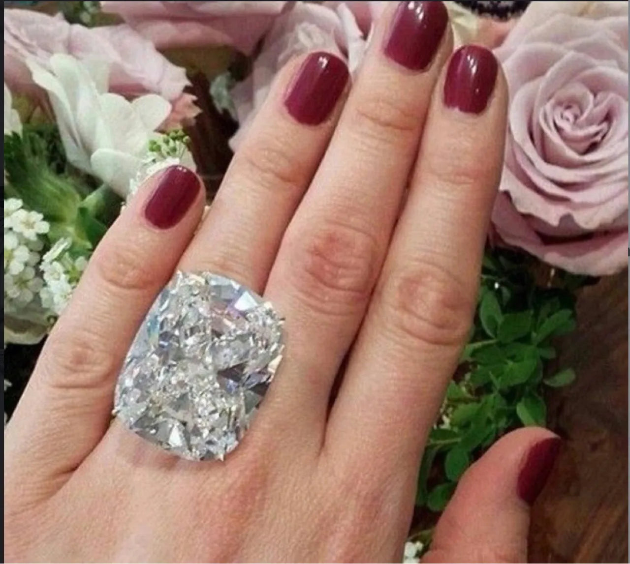 Simple white gold colour ring with an inlaid square diamond geometric design, shown on a model's hand.