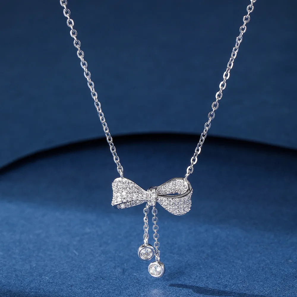 S925 sterling silver bow necklace on collarbone, showing O-ring chain and detailed bow pendant