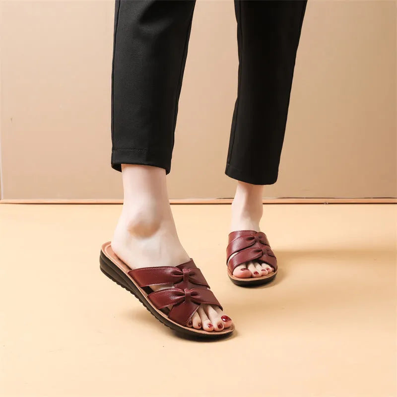 Beige women's cowhide mom sandal slippers with straps and a soft sole on a white background.