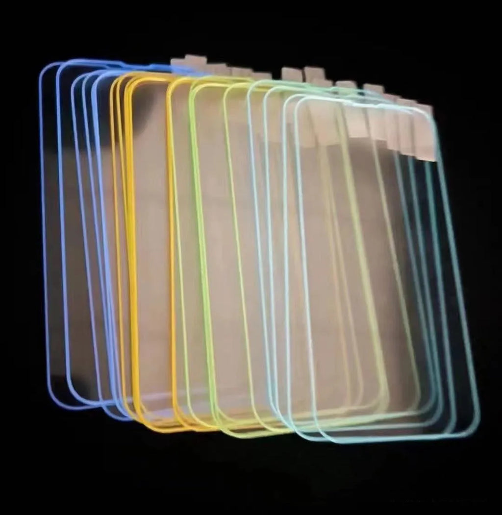 Fluorescent pink luminous tempered glass screen protector applied on an iPhone 13, glowing softly in a dark setting.