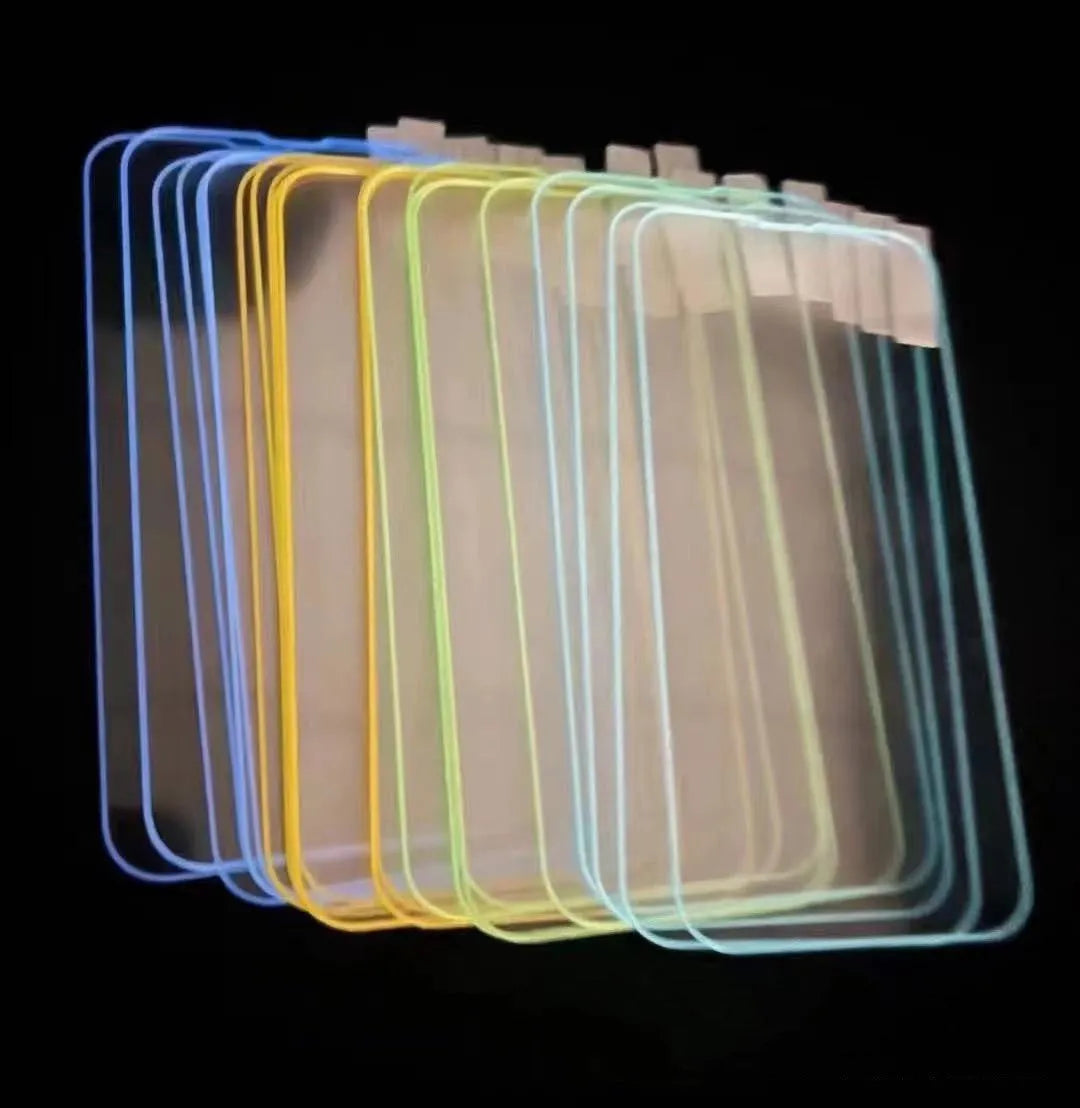 Fluorescent pink luminous tempered glass screen protector applied on an iPhone 13, glowing softly in a dark setting.